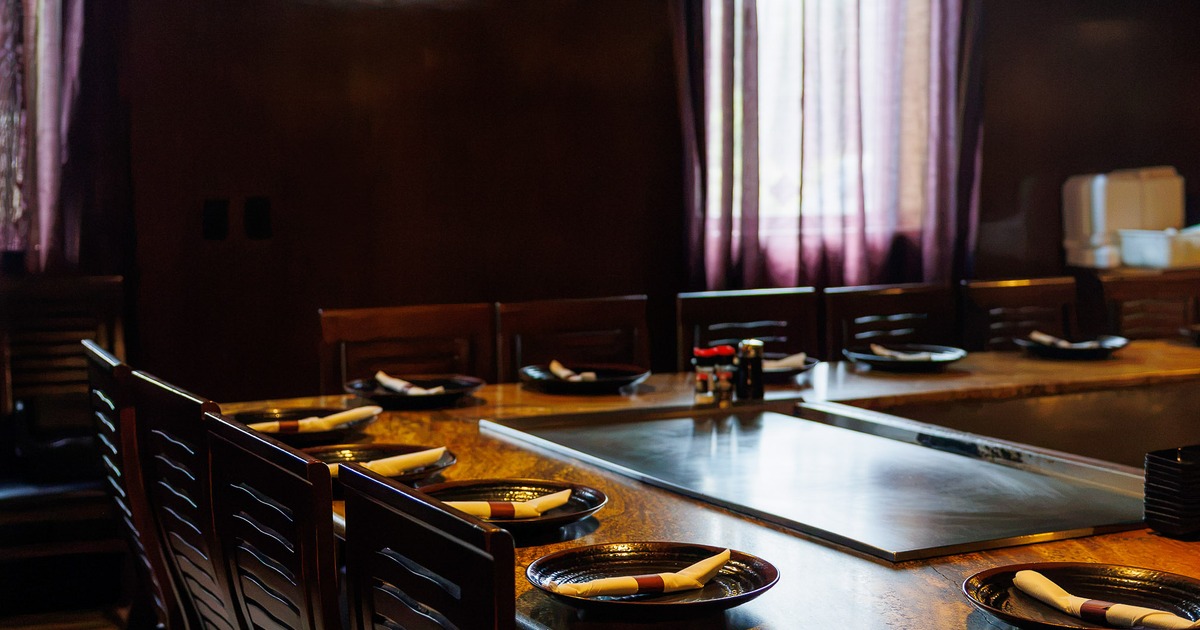Cozy interior dining area with wooden teppanyaki-style table, equipped with a built-in grill