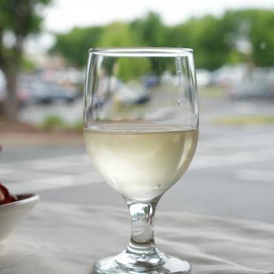 Glass of white wine served on the outdoor table.