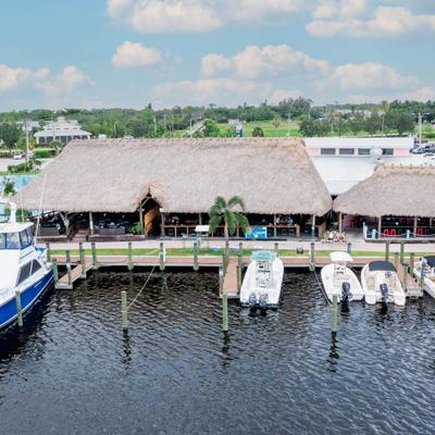 Waterfront tiki bar with boats docked along the pier.