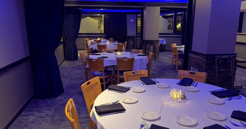 Banquet style room set with tables of six. With black napkins and white table linen.