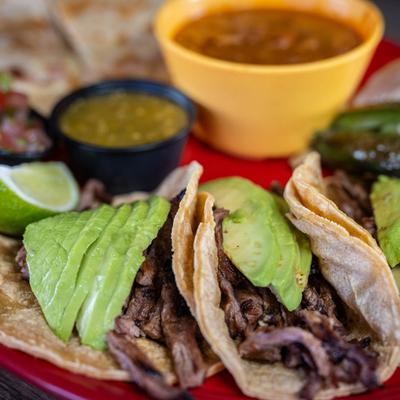 Tacos topped with avocado slices.