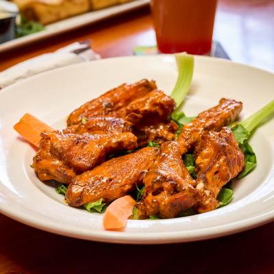 Chicken wings glazed in red sauce with celery.