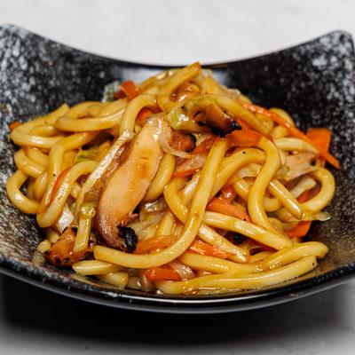 Chicken Udon with sliced carrots, cabbage, and mushrooms.