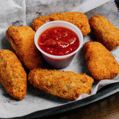 Mozzarella sticks served with a cup of marinara sauce.