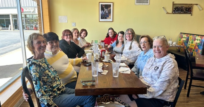 A group pf people sitting around a table at a restaurant
