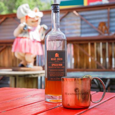 Mule cocktail served in a copper mug, accompanied with a bottle of spiced rum