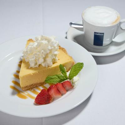 Key lime pie slice served with a cappuccino.