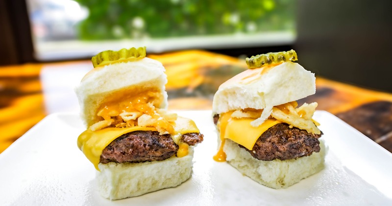 Cheeseburger sliders with crispy onions, cheese sauce and pickle slices