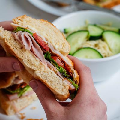 Hands holding a sandwich.