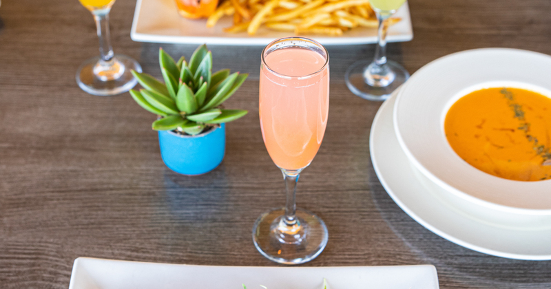 Mimosa drink and dishes in the back