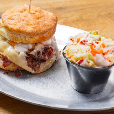 Lowcountry biscuit sandwich with coleslaw on the side.