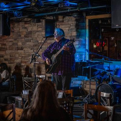 Interior, a guitar player performing on a stage.