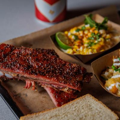 Ribs with sides of loaded potato and creamy corn.