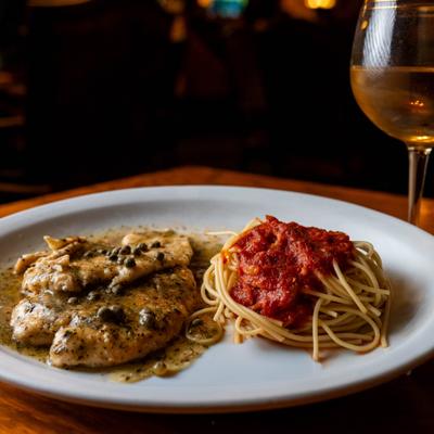 Chicken piccata with capers, spaghetti, and marinara sauce.