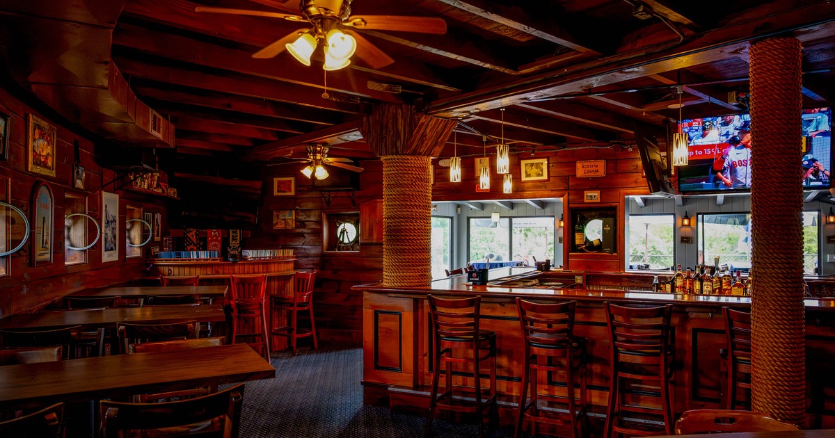 Interior of a cozy wooden bar with tables, a bar counter