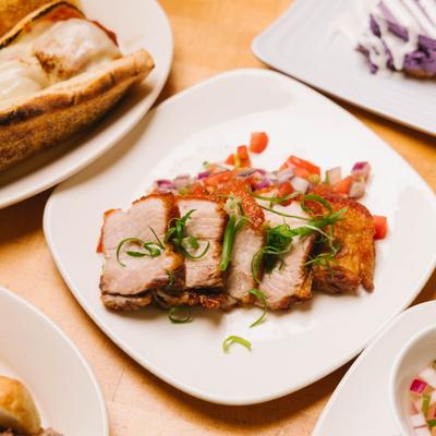 Sliced pork served with diced vegetables.