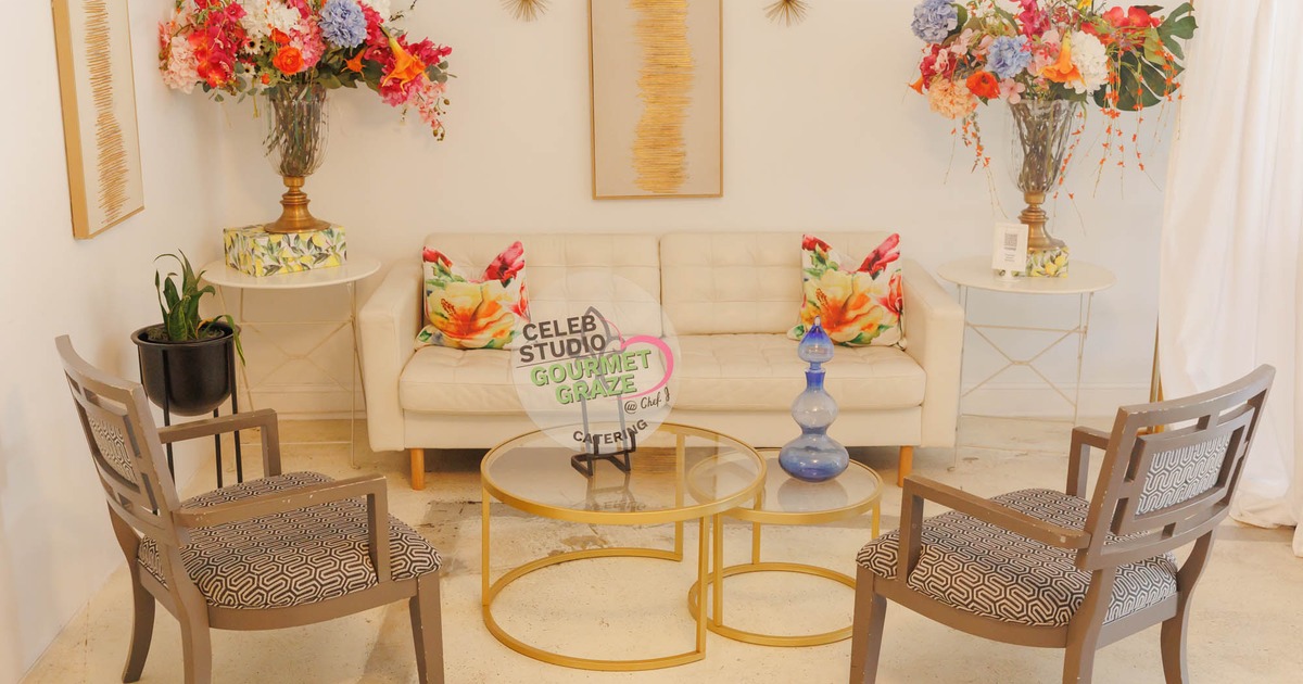 A stylish seating area with a cream sofa, floral cushions, glass tables