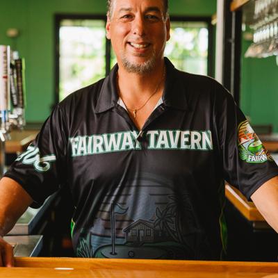 Person wearing Fairway Tavern shirt behind a counter.