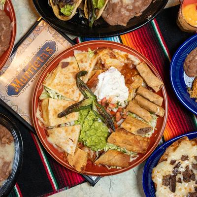A large Mexican platter features quesadillas, taquitos, guacamole, and sour cream.