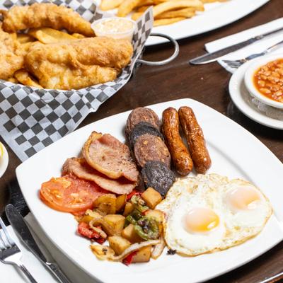 Irish breakfast with eggs, sausage, black and white pudding, baked beans. and potatoes.