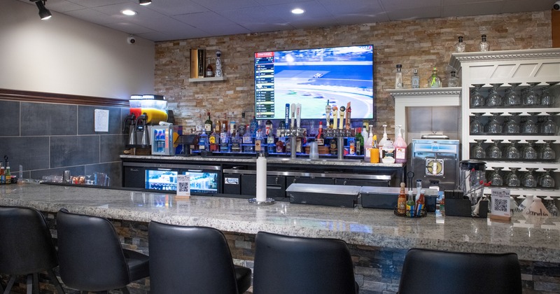 Interior, bar, bar stools, drink rack, tv screen above