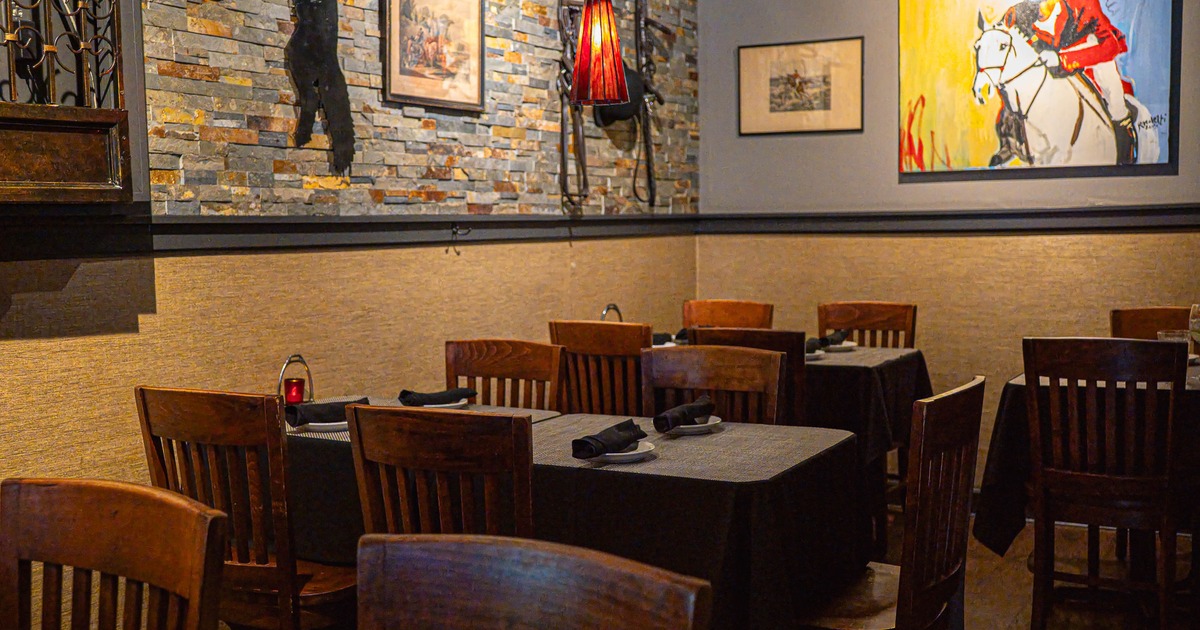 Interior view of a restaurant with wooden tables, dark cloths