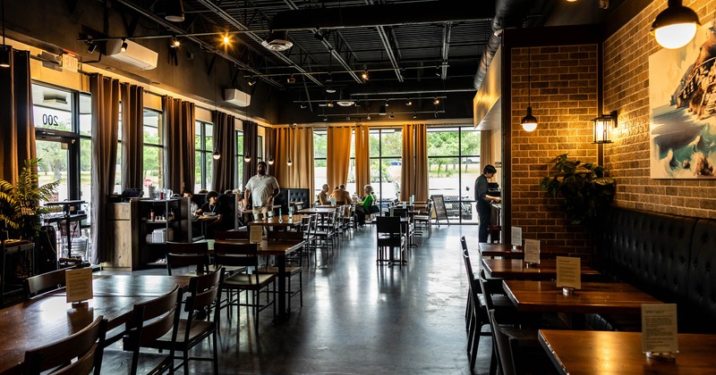 Interior, wide open view of a seating area with a few guests