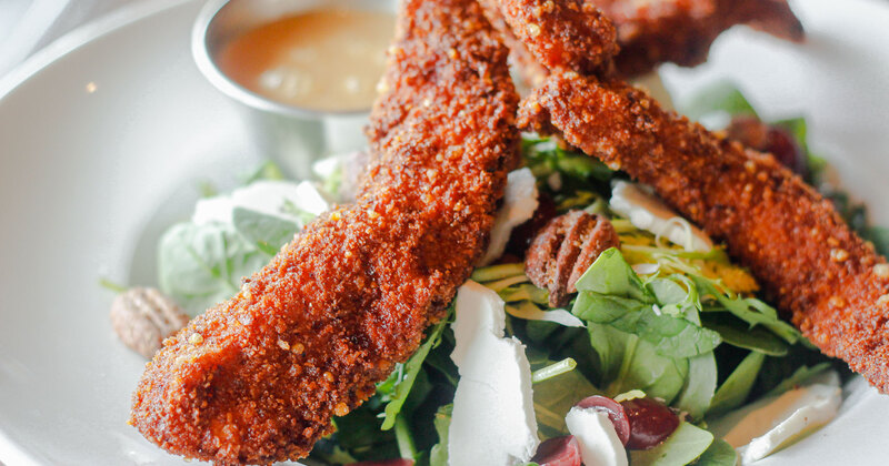 Fried chicken salad with cheese, greens and dressing