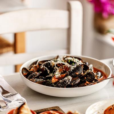 A plate of mussels saganaki on a table.