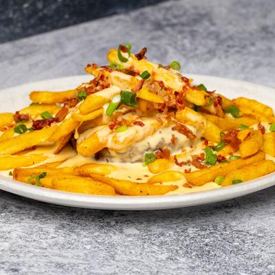 Loaded fries with cheese sauce, bacon bits, and chopped scallions.