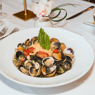 Clam linguine pasta with cherry tomatoes and toasted breadcrumbs.