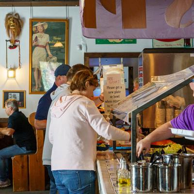 People serving themselves at the buffet.