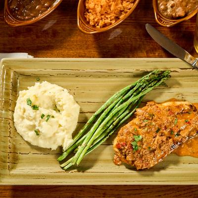 Chorizo Chicken served with asparagus and mashed potatoes.