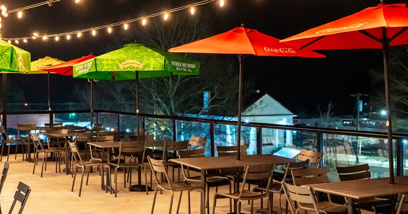Exterior, terrace seating area, partially covered with parasols, small hanging lanterns