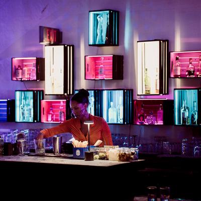 Bartender making cocktails behind the bar.