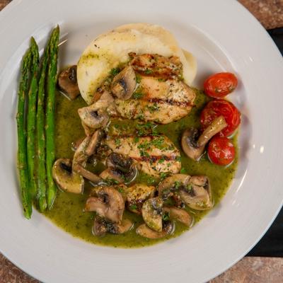 Charbroiled chicken breast, served with garlic mashed potatoes, asparagus, and mushrooms.