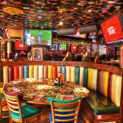 A vibrant diner interior with colorful striped booth seating and a round table set for dining