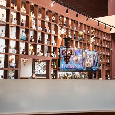 A large, multi-tiered wooden shelving unit displaying numerous liquor bottles.