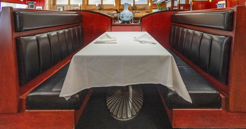 Restaurant booth with red and black upholstery, white-covered table