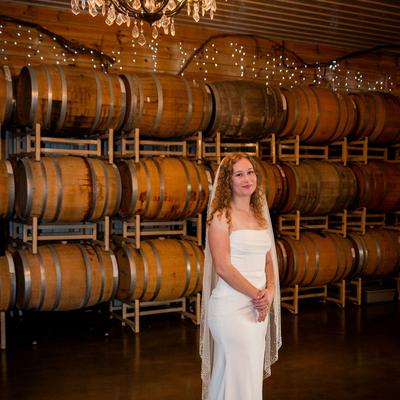 Bride standing in Barrel Room in Wedding Dress.