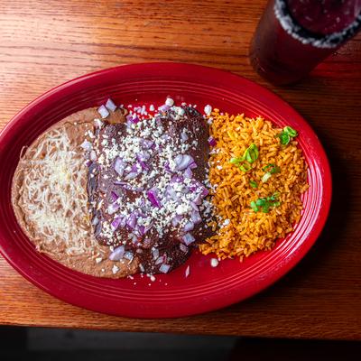 Mole enchilada served with rice and refried beans.