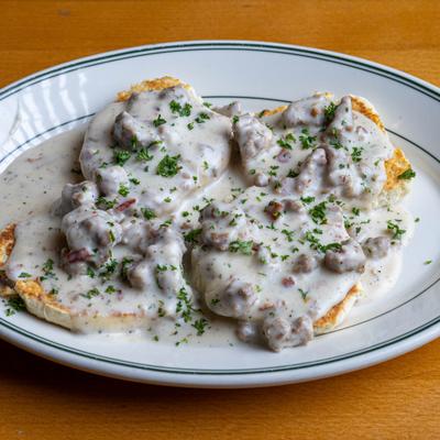 Biscuits and Gravy garnished with fresh herbs.