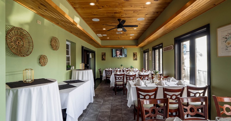 Restaurant dining room with neatly set tables and wooden ceiling