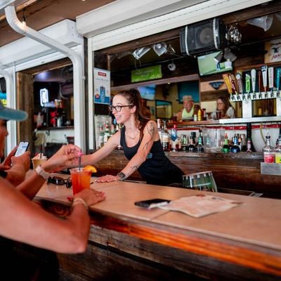 Bartender serving customers at a bar.