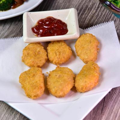 Chicken nuggets served with a dipping sauce.