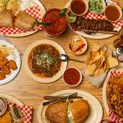 Assorted menu dishes and drinks spread on a table, overhead view.
