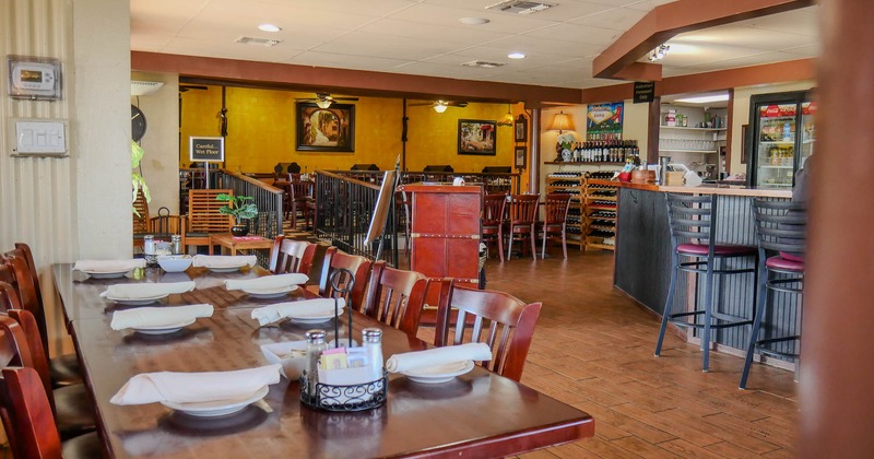 Interior, dining  area, long table setup, bar on the right, elevated seating area in the back