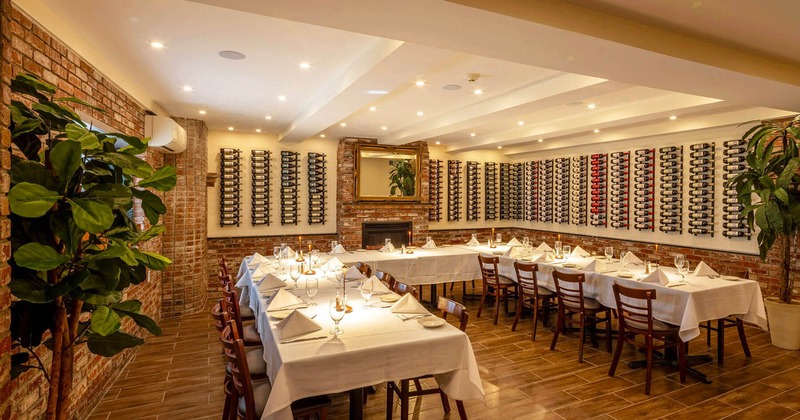 Interior, private dining area, ''U'' shaped event table setup with chairs, wine bottles on the walls