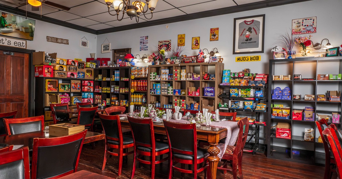 Interior of a cozy restaurant dining area with wooden furniture and colorful shelves filled with groceries