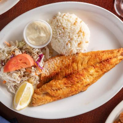 Oven-baked walleye fish fillet with rice, cabbage salad, and sauce.
